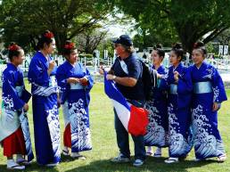 French Rugby fan interacting with Japanese girls in kimonos outside Kumamoto Castle