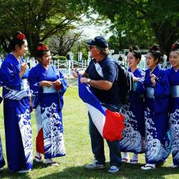 French Rugby fan interacting with Japanese girls in kimonos outside Kumamoto Castle